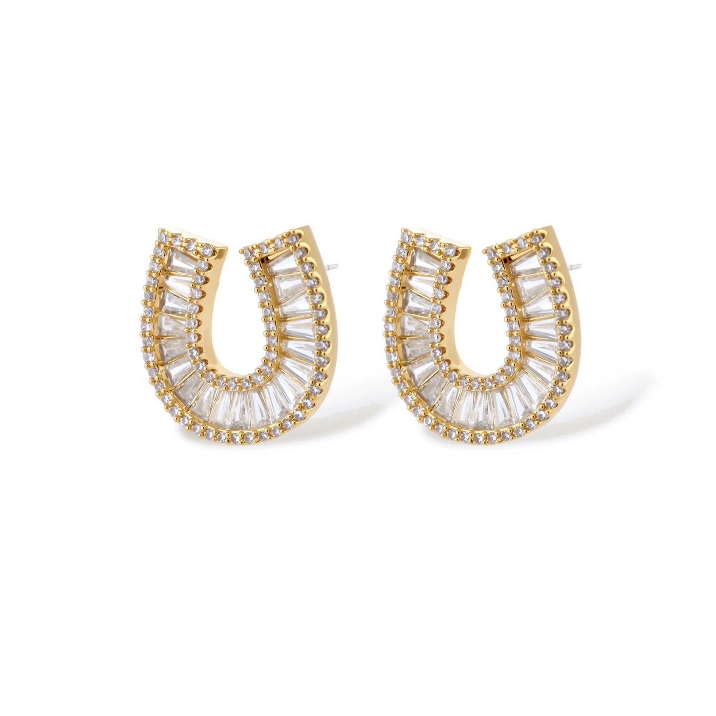 Gold-plated horseshoe necklace and earring set with baguette and round crystals arranged in geometric pattern on white background.