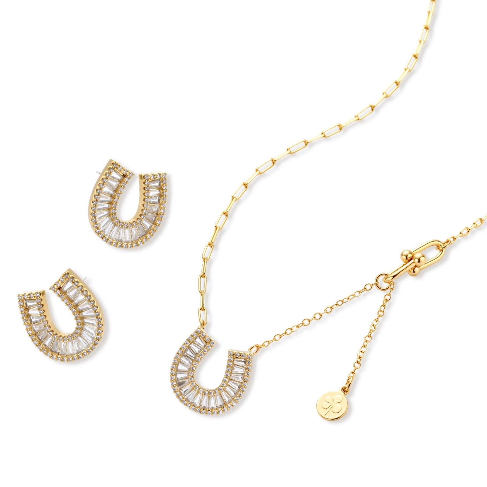 Gold-plated horseshoe necklace and earring set with baguette and round crystals arranged in geometric pattern on white background.